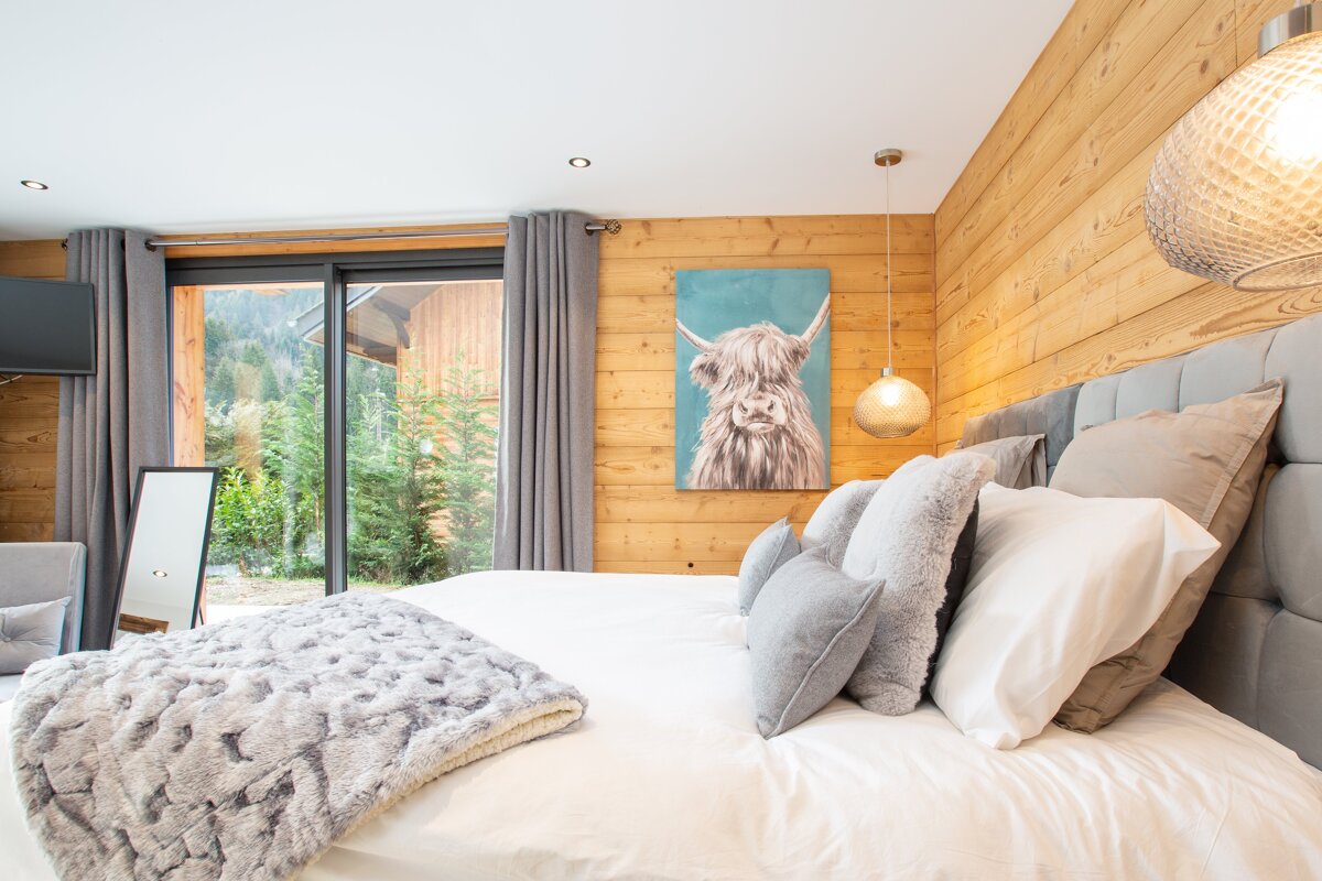 A bedroom with a painting of a yak on the wall