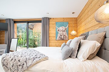 A bedroom with a painting of a yak on the wall