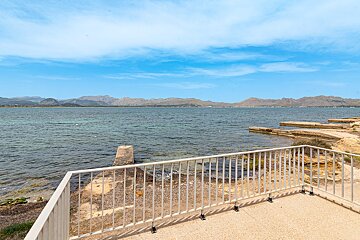 A balcony overlooking a body of water with mountains in the background