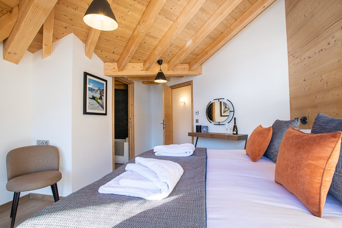 A bedroom with a mirror and a picture on the wall