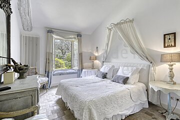 A bedroom with a canopy bed and a window
