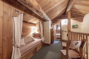 A wooden hallway with a couch and a picture on the wall