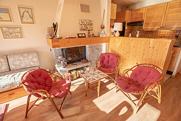 A living room with a fireplace and two chairs