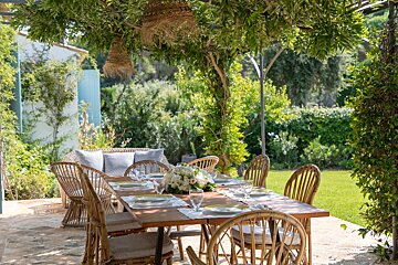 A table with plates and glasses on it under a pergola