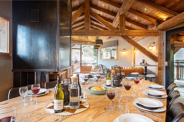 A bottle of wine sits on a wooden table
