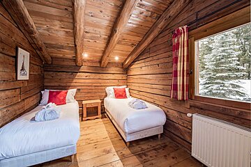 A bedroom with two beds and a picture of the eiffel tower on the wall