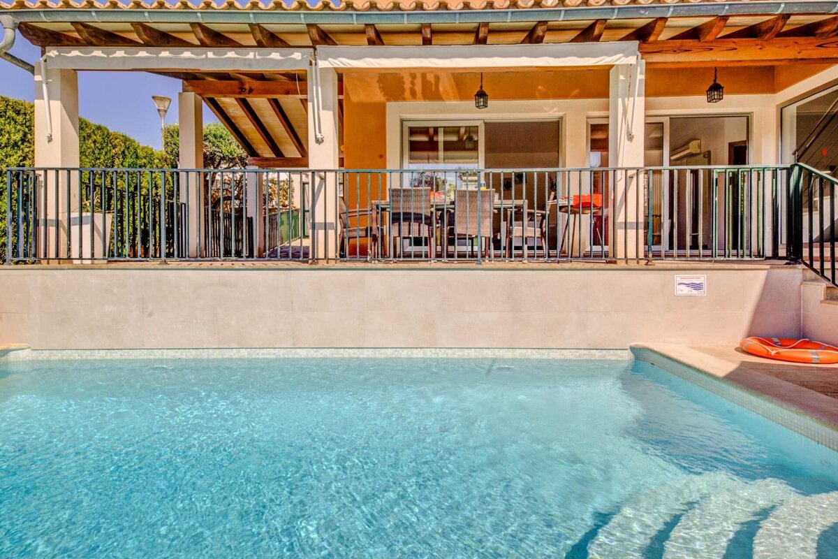 A house with a swimming pool in front of it