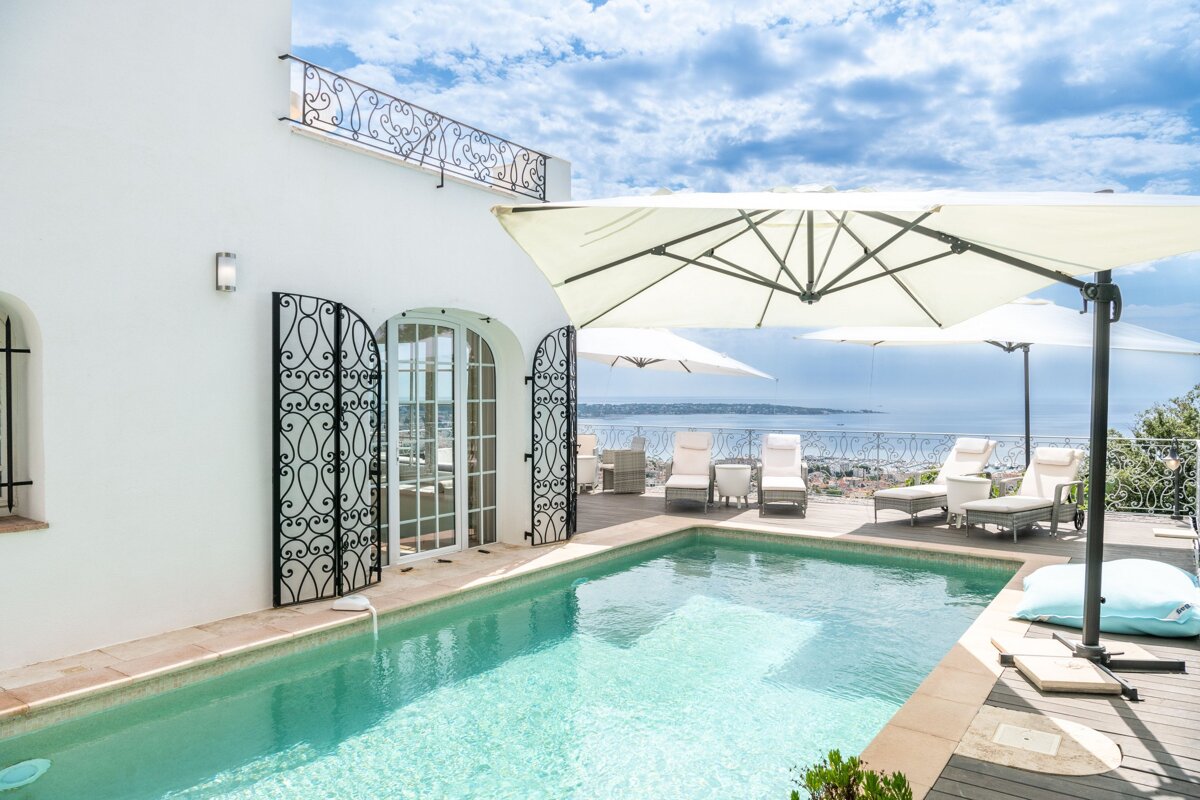 A large white house with a swimming pool in front of it