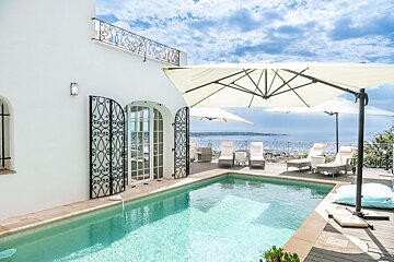 A large white house with a swimming pool in front of it