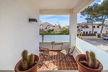 A balcony with a table and chairs and potted plants
