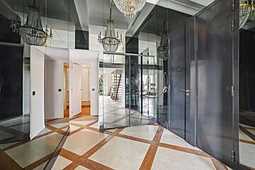A mirrored hallway with a chandelier hanging from the ceiling
