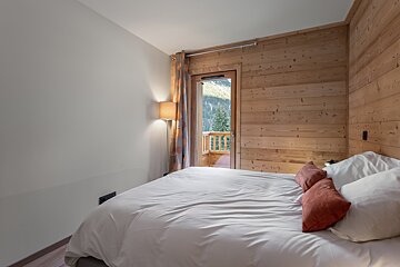 A bedroom with a bed and a wooden wall