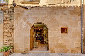 A stone building with a glass door that leads to a living room