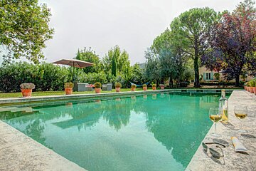 A bottle of wine sits on the edge of a swimming pool