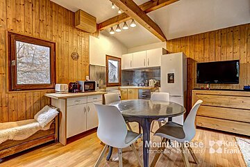 A kitchen with a table and chairs and a mountain base real estate logo