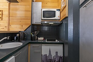 A kitchen with a picture of new york city on the refrigerator door