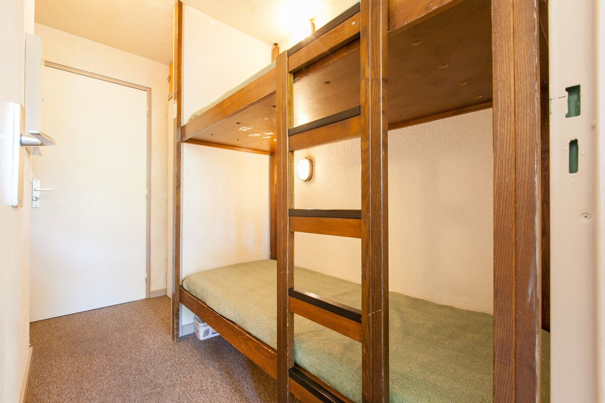 A bunk bed with a green blanket on it