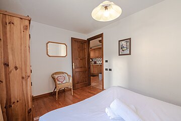 A bedroom with a bed and a chair with a heart on it