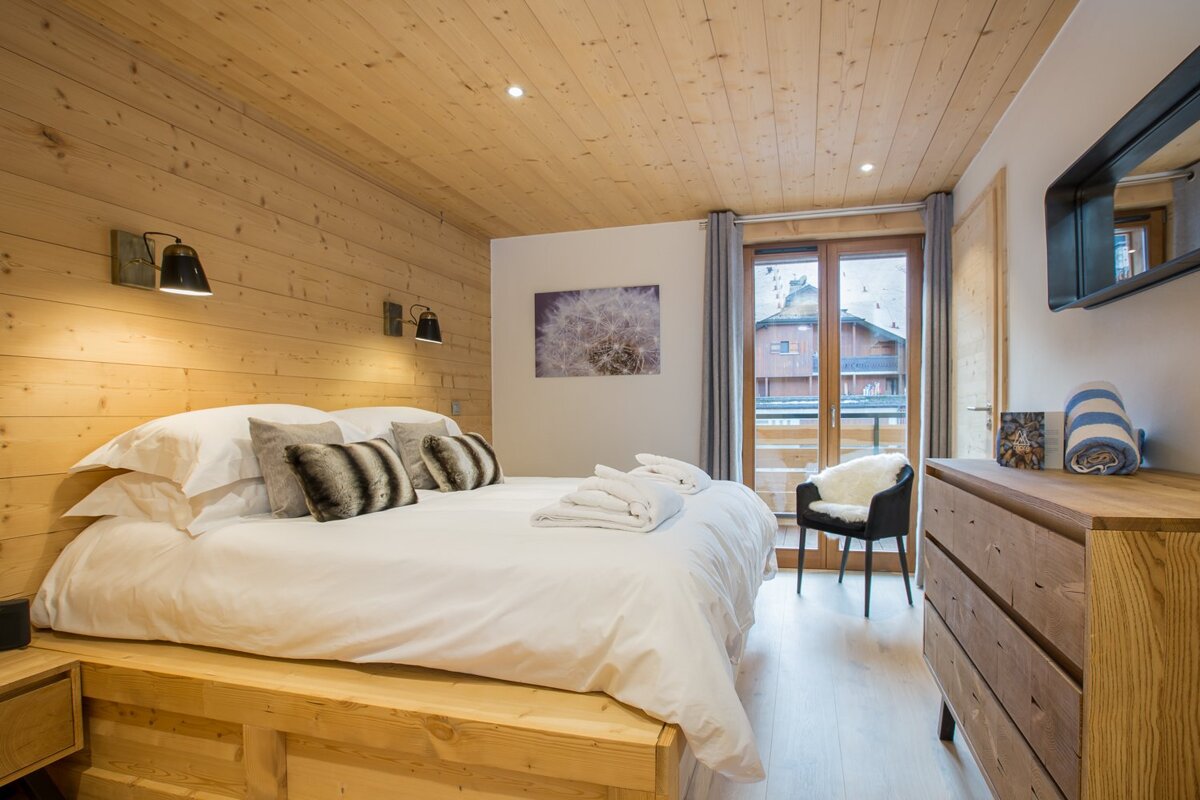 A bedroom with a large bed and a dresser