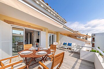 A bottle of wine sits on a table on a balcony