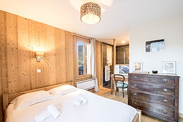A bedroom with a large bed and a dresser