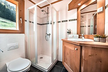 A bathroom with a toilet a sink and a shower