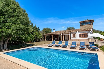 A house with a large swimming pool in front of it