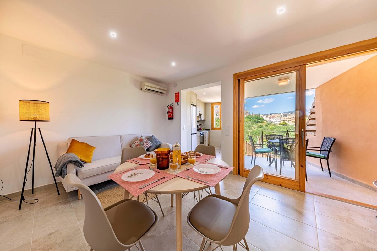 A living room with a table and chairs and a fire extinguisher on the wall