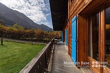 A balcony with blue shutters and a sign that says mountain base