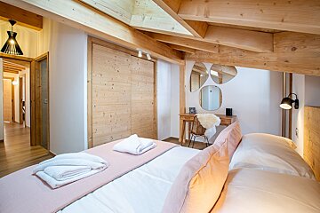 A bedroom with a bed and a mirror on the wall