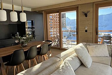 A living room with a couch and a table and chairs