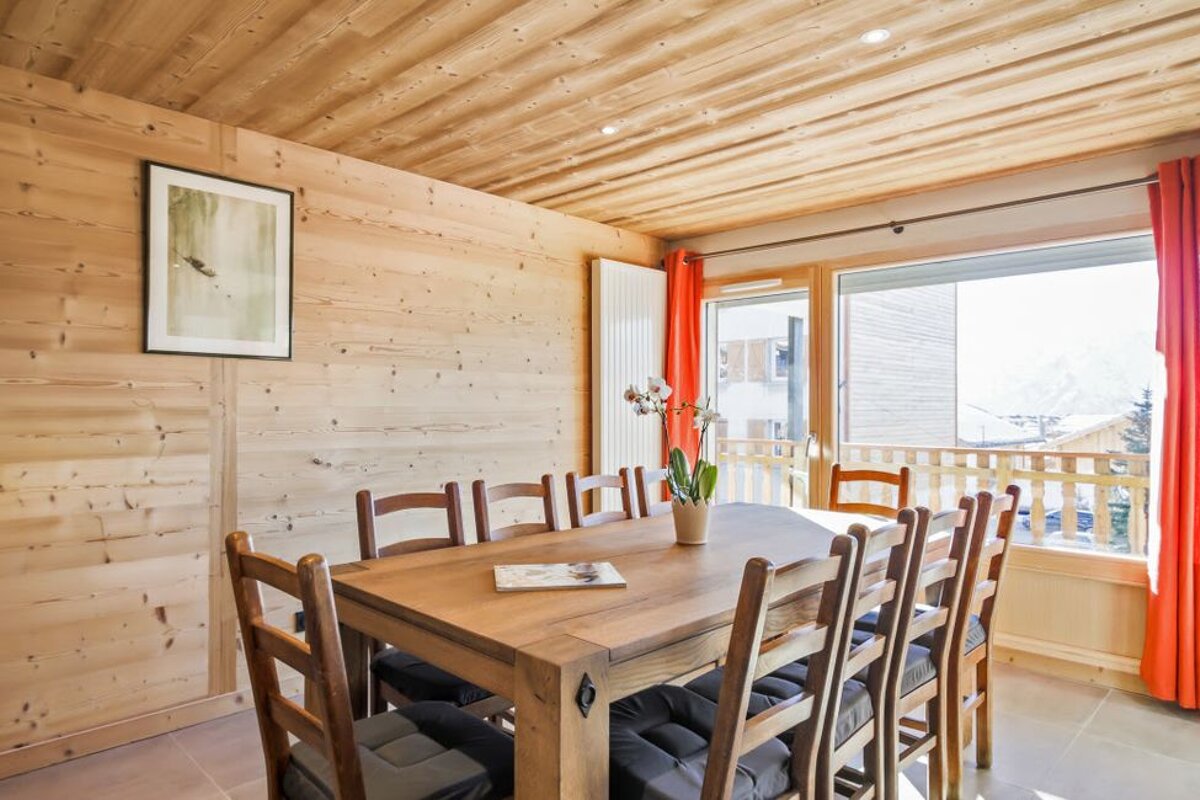 A dining room with a wooden table and chairs