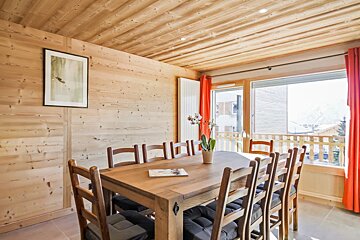 A dining room with a wooden table and chairs