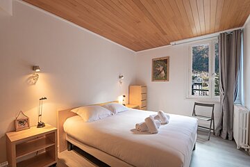 A bedroom with a bed and a picture on the wall