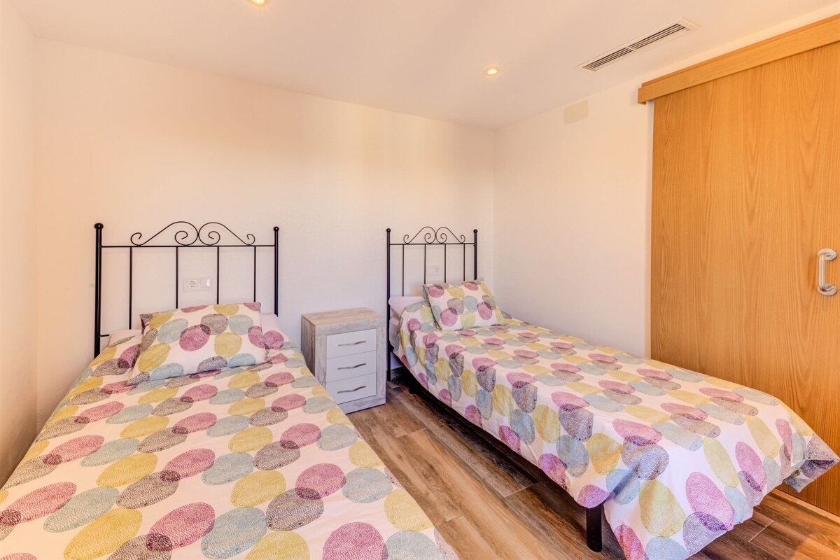 A bedroom with two beds and a sliding door