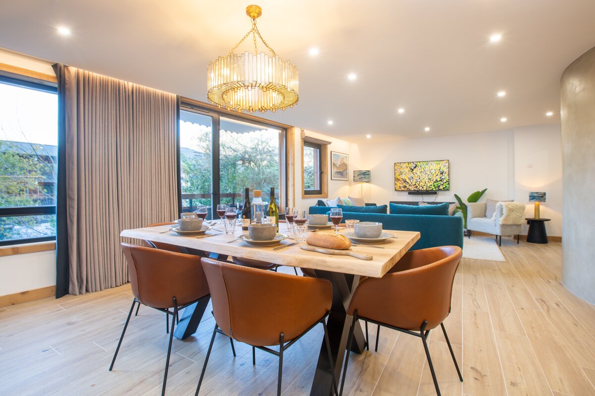 A dining room with a table and chairs and a chandelier