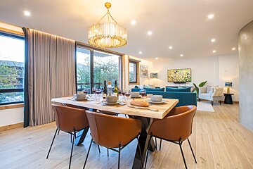 A dining room with a table and chairs and a chandelier