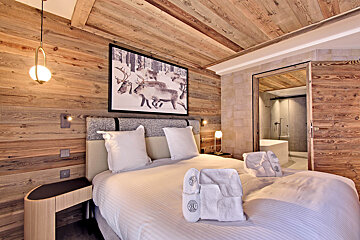 A bedroom with a picture of reindeer on the wall