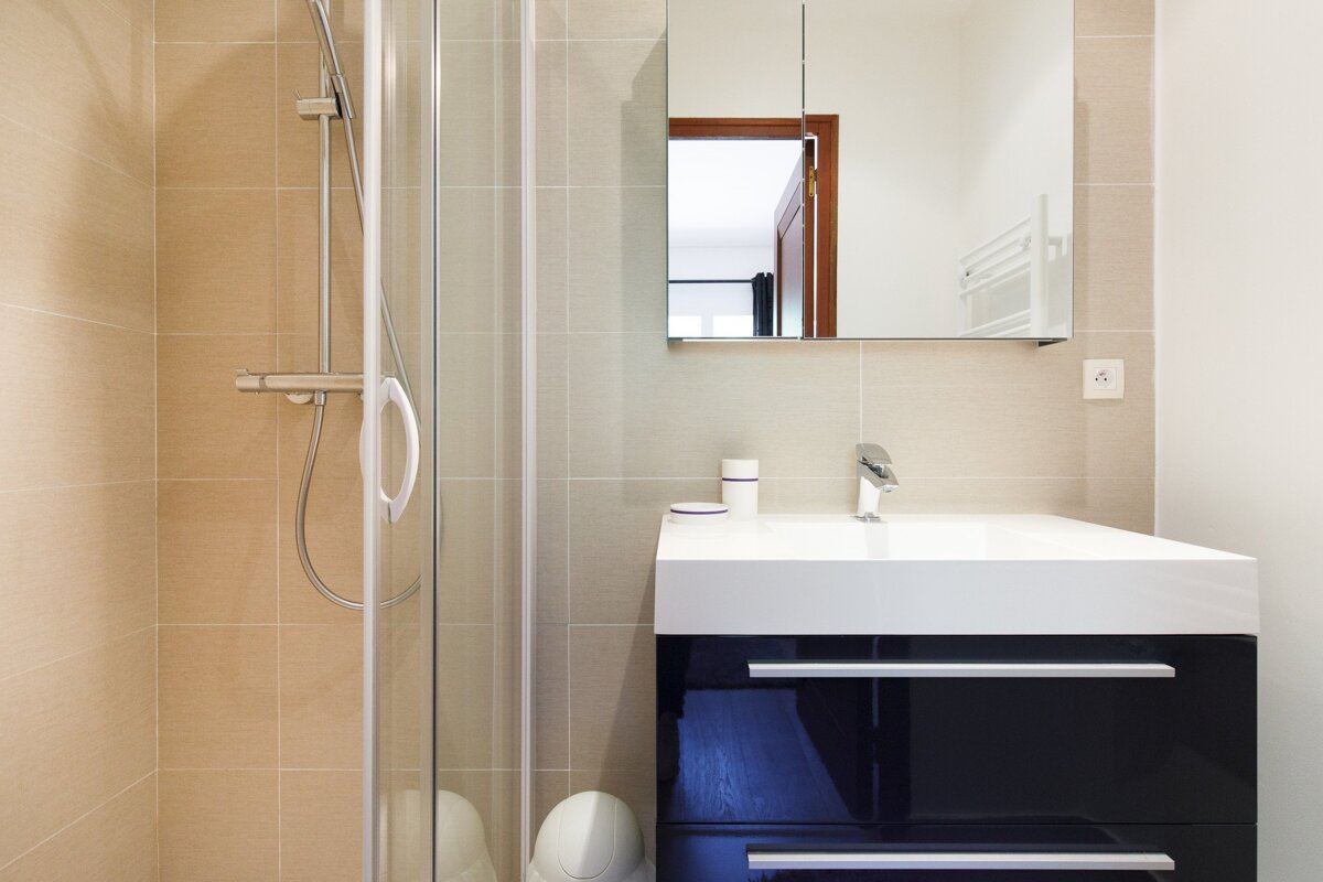 A bathroom with a sink and a shower stall