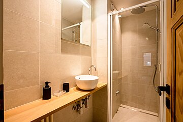 A bathroom with a sink and a walk in shower