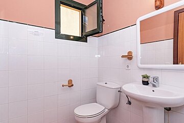 A bathroom with a toilet a sink and a mirror