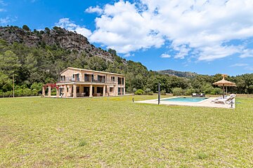 A large house with a swimming pool in front of it