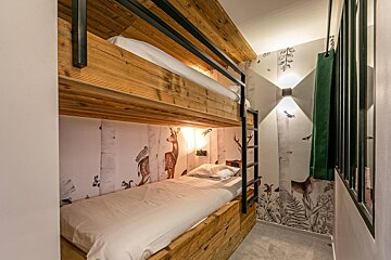 A bunk bed in a room with a mural of animals on the wall