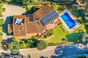 An aerial view of a house with solar panels on the roof