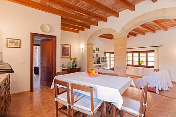 A dining room table with a bowl of fruit on it