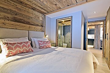 A bedroom with a white bed and pink pillows