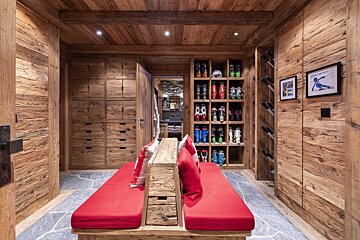 A wooden room with a bench and a picture of a skier on the wall