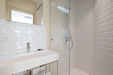 A bathroom with a sink and a walk in shower