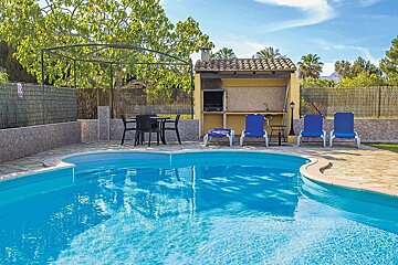 A swimming pool with a grill and chairs in the background
