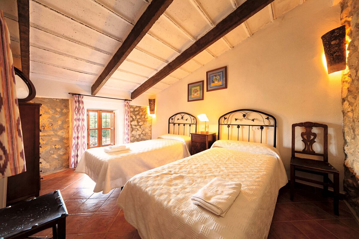 A bedroom with two twin beds and a chair